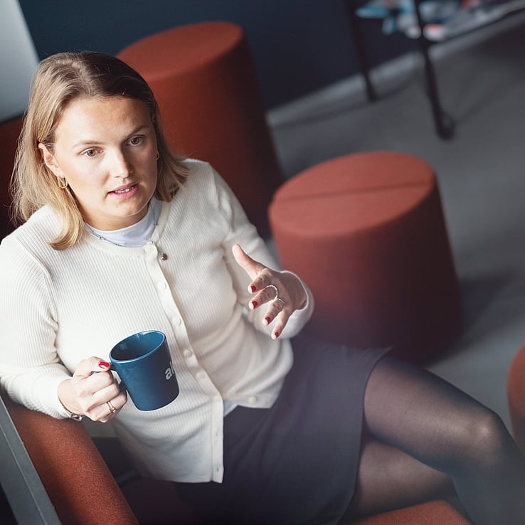 Kvinne med kaffekopp i kontormiljø